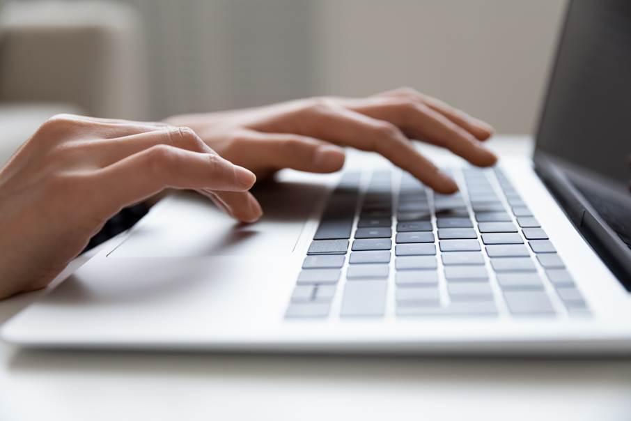 E-tjänster förskola och skola En kvinna skriver på ett tangentbord